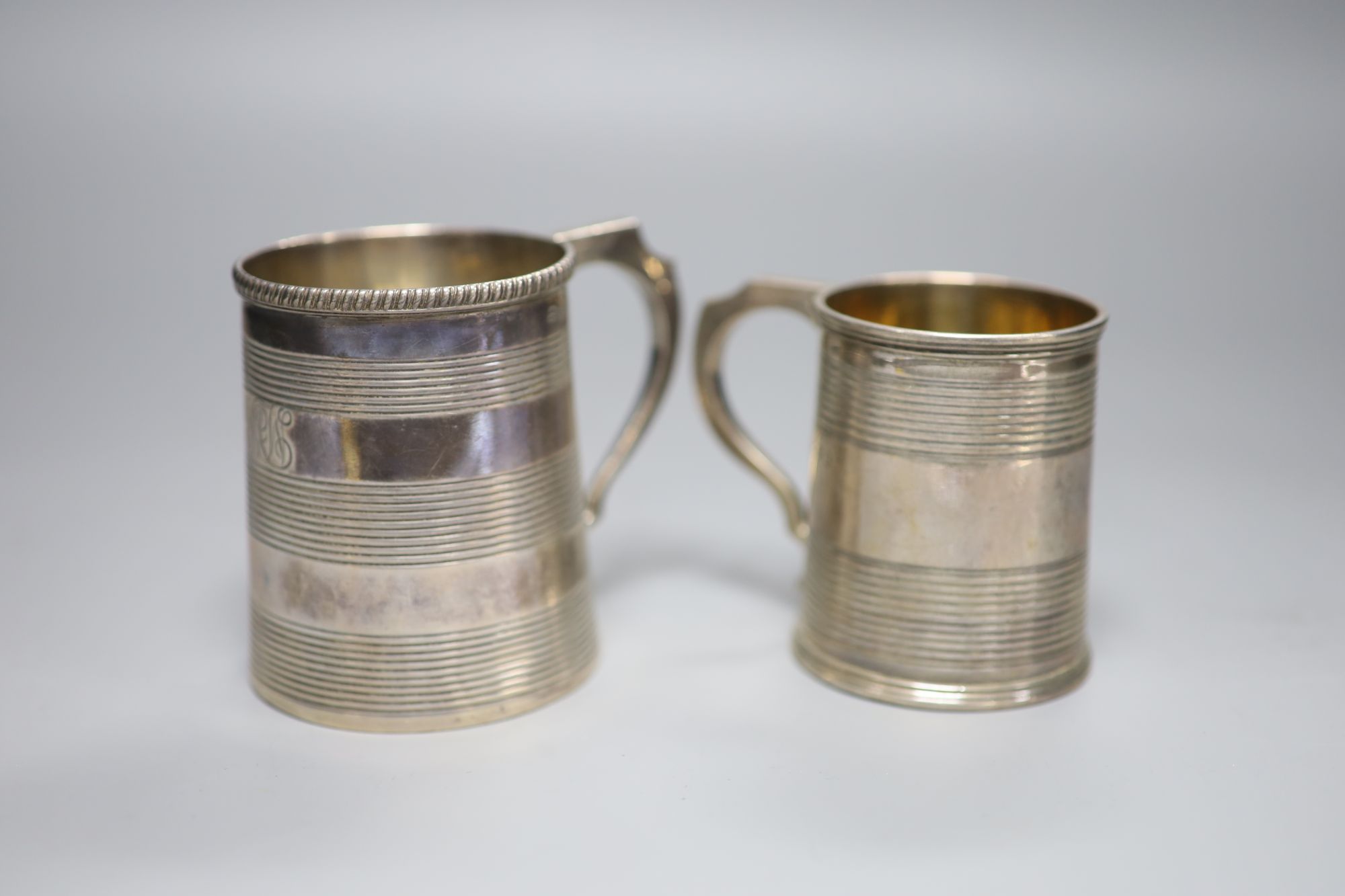 A George III reeded silver christening mug, London, 1812 and one other later mug, London, 1827,